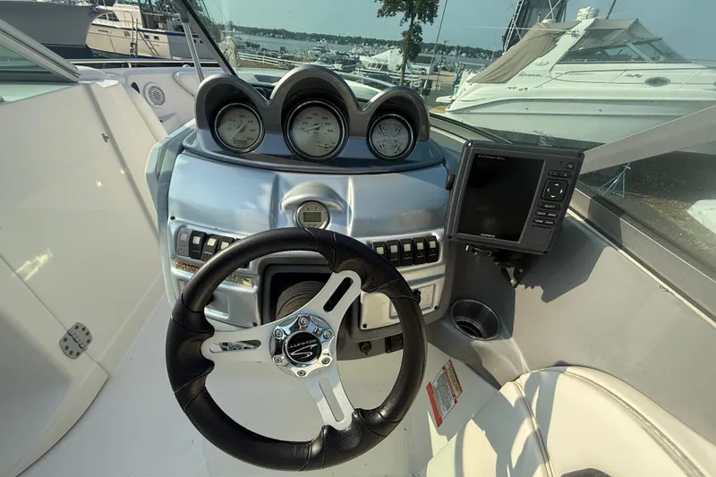 Slide: The Image of 2008 Monterey 254FS boat dashboard with steering wheel and navigation system. - 17