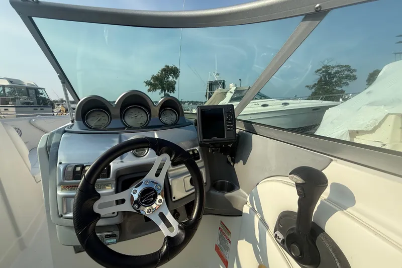 Slide: The Image of 2008 Monterey 254FS boat dashboard with steering wheel and gauges. - 2