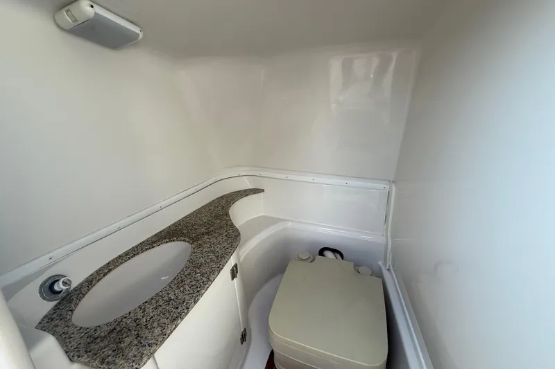 Slide: The Image of Compact bathroom in 2008 Monterey 254FS boat with granite countertop and toilet. - 23