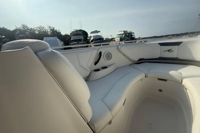 Slide: The Image of 2008 Monterey 254FS boat interior with white seating and scenic marina view. - 7
