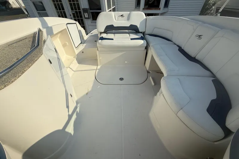 Slide: The Image of 2008 Monterey 254FS boat interior with white seating and storage compartments. - 9