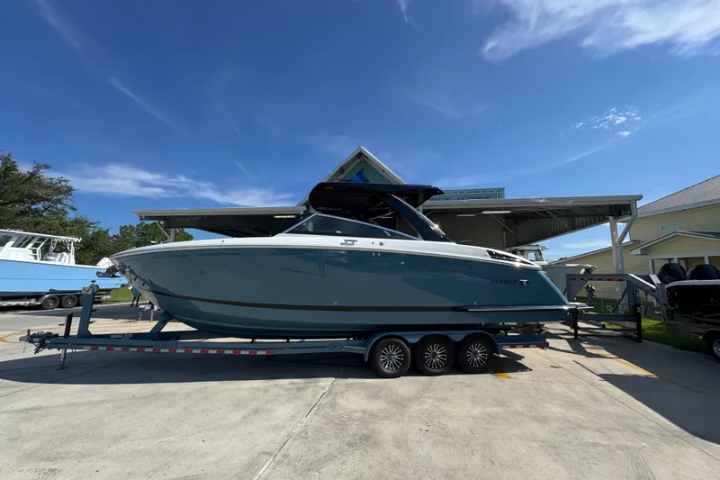 Slide: The Image of 2024 Cobalt R33 boat on trailer under clear blue sky. - 1