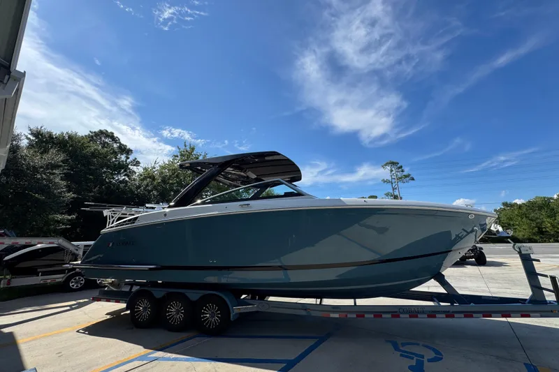 Slide: The Image of 2024 Cobalt R33 boat on trailer under clear blue sky. - 10
