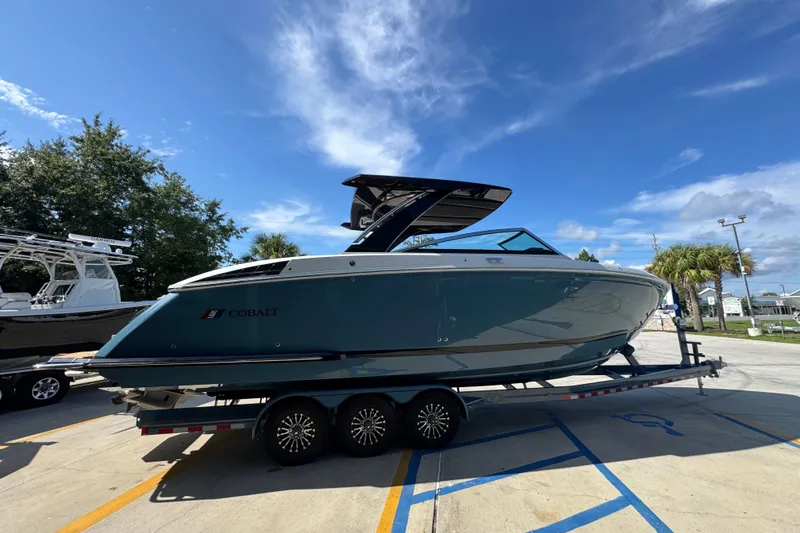 Slide: The Image of 2024 Cobalt R33 boat on trailer under clear blue sky. - 11