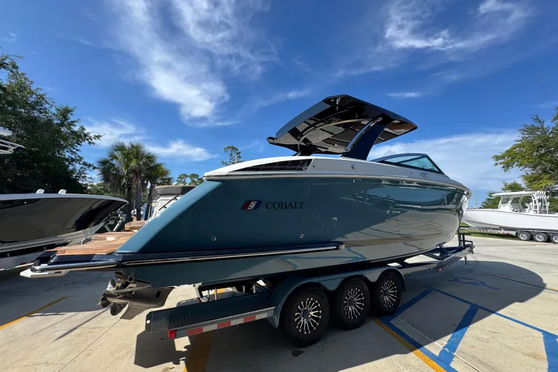Slide: The Image of 2024 Cobalt R33 boat on trailer under clear blue sky. - 12
