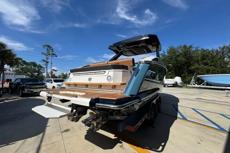 Slide: The Image of 2024 Cobalt R33 boat on trailer, showcasing sleek design and spacious deck under clear blue sky. - 13