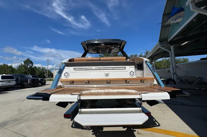 Slide: The Image of 2024 Cobalt R33 boat rear view with teak swim platform under clear blue sky. - 15
