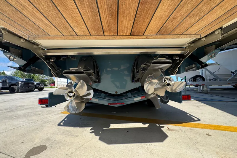 Slide: The Image of 2024 Cobalt R33 boat with dual propellers and wooden deck, parked outdoors. - 16