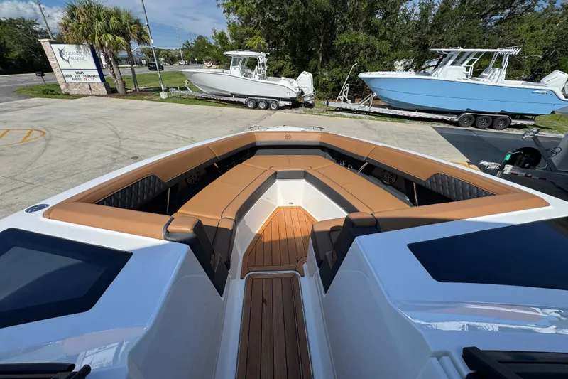 Slide: The Image of 2024 Cobalt R33 boat with luxurious seating and sleek design at a marina. - 21