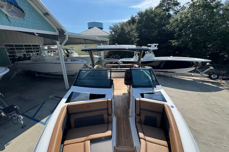 Slide: The Image of 2024 Cobalt R33 boat with sleek design, docked at a marina, surrounded by other boats. - 23