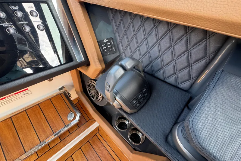 Slide: The Image of 2024 Cobalt R33 boat interior with control panel, quilted upholstery, and wood flooring. - 28
