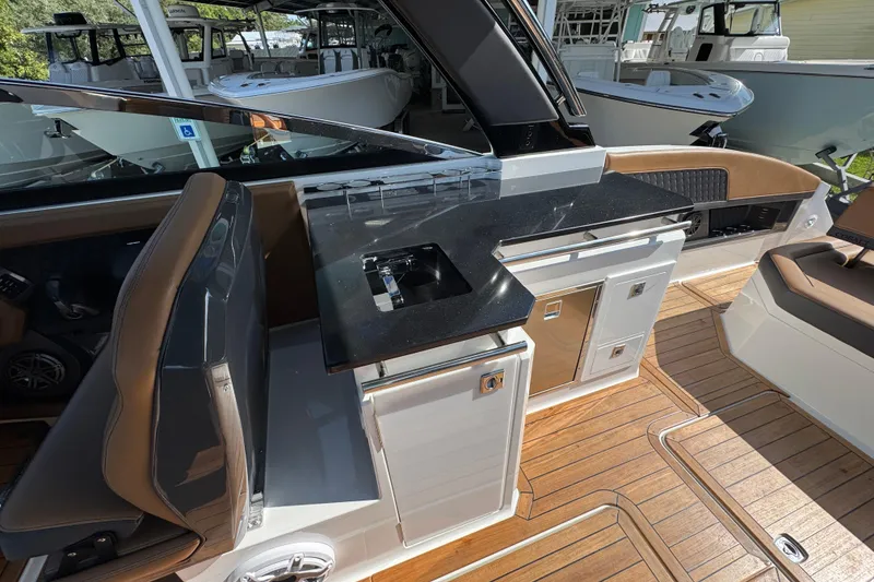 Slide: The Image of 2024 Cobalt R33 boat interior with sleek kitchenette and luxurious seating. - 33