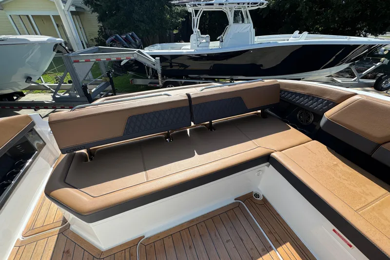 Slide: The Image of 2024 Cobalt R33 boat interior with tan seating and wood flooring. - 38