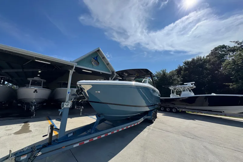 Slide: The Image of 2024 Cobalt R33 boat on trailer under sunny sky at marina. - 5