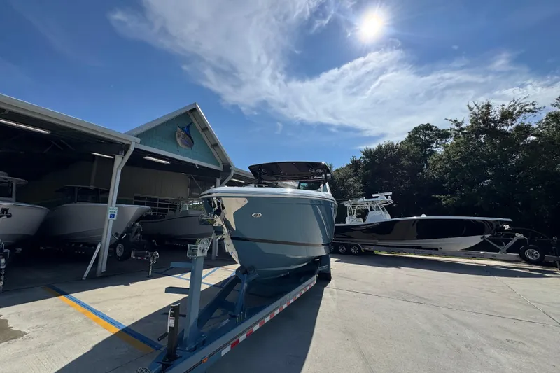 Slide: The Image of 2024 Cobalt R33 boat on trailer under sunny sky at marina. - 6