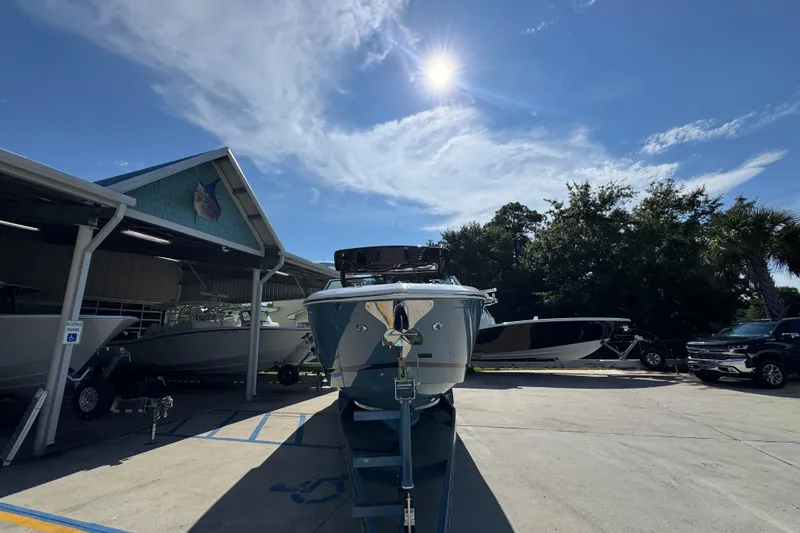 Slide: The Image of 2024 Cobalt R33 boat parked outdoors under a sunny sky. - 7