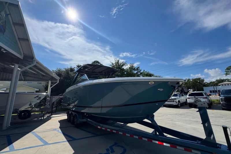 Slide: The Image of 2024 Cobalt R33 boat on trailer under sunny sky at dealership. - 8