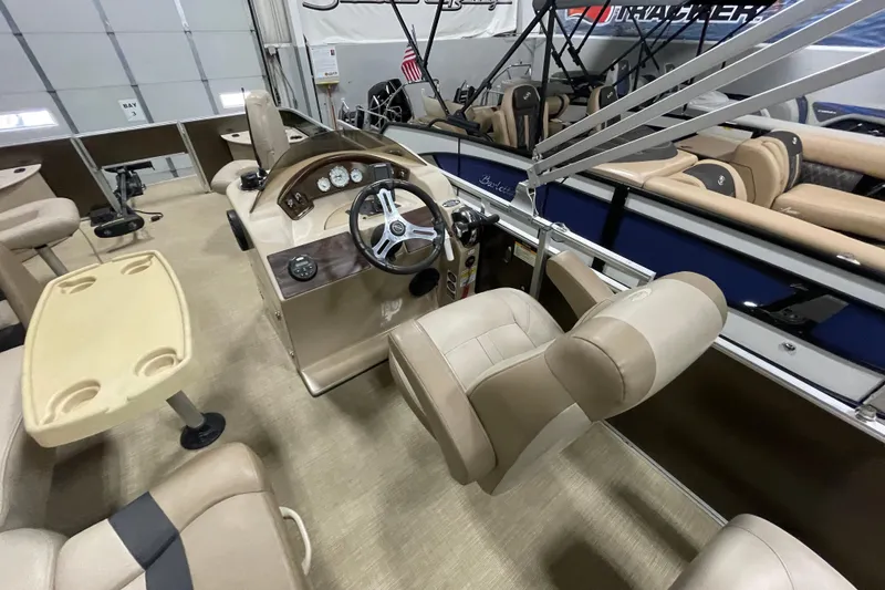 Slide: The Image of 2018 Crestliner FS 220 boat interior with beige seating and steering console. - 12