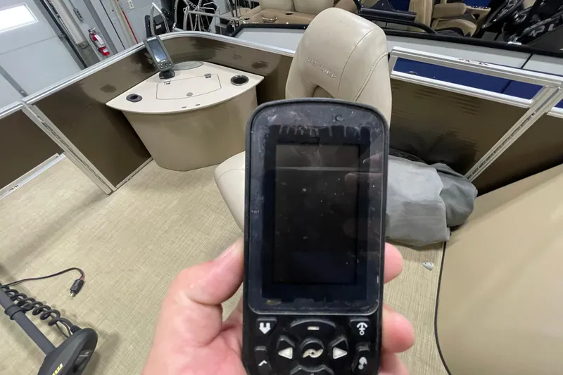 Slide: The Image of Hand holding a device inside a 2018 Crestliner FS 220 boat interior. - 20