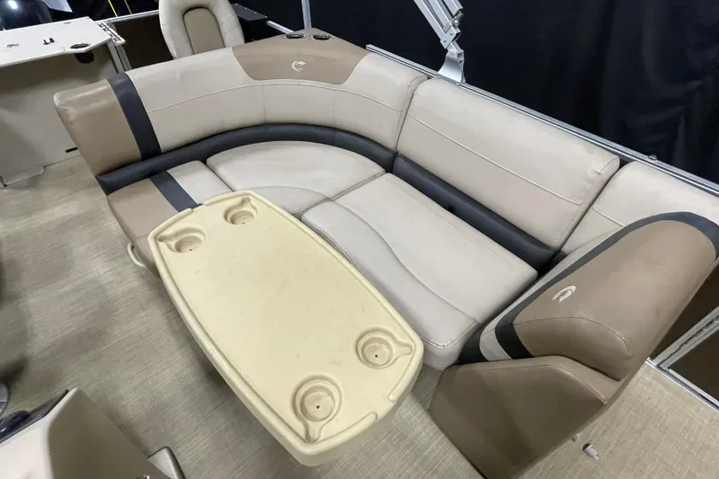 Slide: The Image of 2018 Crestliner FS 220 boat interior with beige seating and a table with cup holders. - 9
