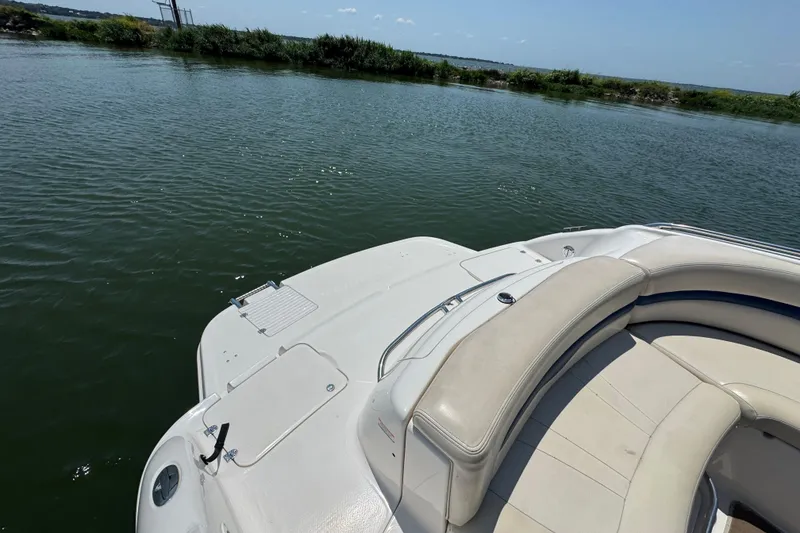 Slide: The Image of 2001 Chaparral 230 SSi boat with beige seating, docked on a calm lake. - 16