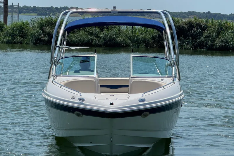 Slide: The Image of 2001 Chaparral 230 SSi boat on calm water with lush greenery in the background. - 2