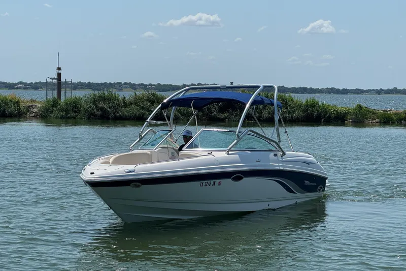 Slide: The Image of 2001 Chaparral 230 SSi boat on calm water with blue canopy. - 4