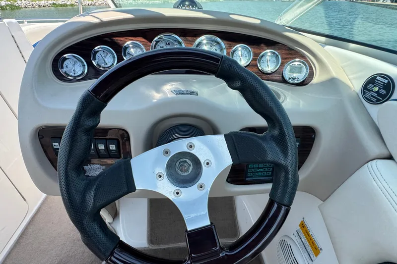 Slide: The Image of Steering wheel and dashboard of 2001 Chaparral 230 SSi boat, featuring gauges and controls. - 9