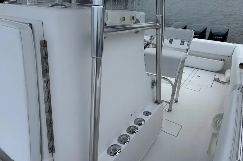 Slide: The Image of 2002 Contender 36 Open boat interior with seating and rod holders, docked by the water. - 13
