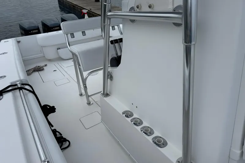 Slide: The Image of 2002 Contender 36 Open boat interior with seating and rod holders, docked by the water. - 14
