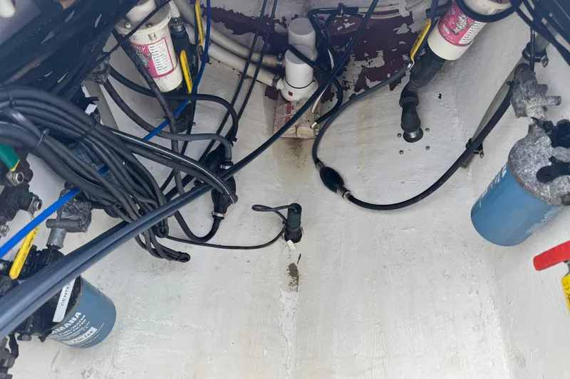 Slide: The Image of Engine compartment of a 2002 Contender 36 Open boat with visible wiring and filters. - 18