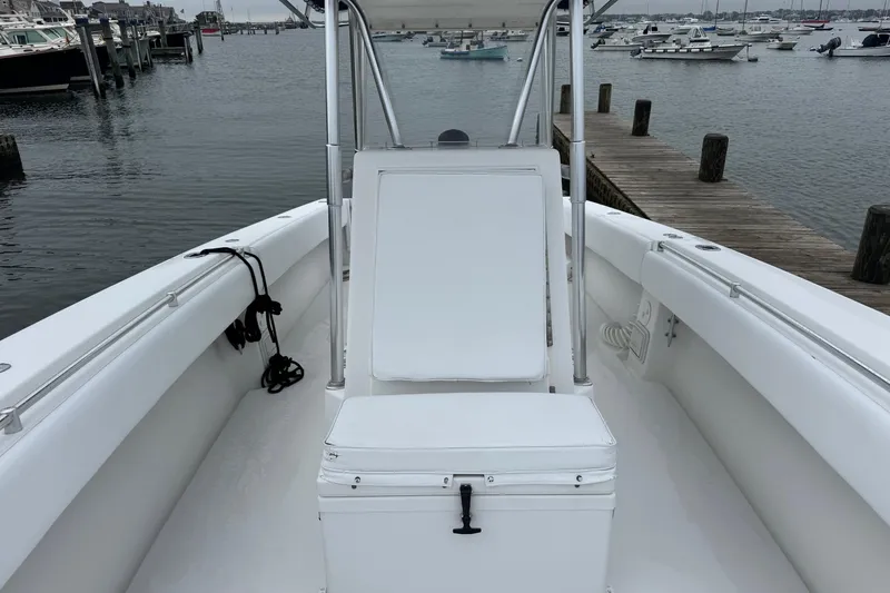 Slide: The Image of 2002 Contender 36 Open boat interior at dock, featuring white seating and calm waters. - 7