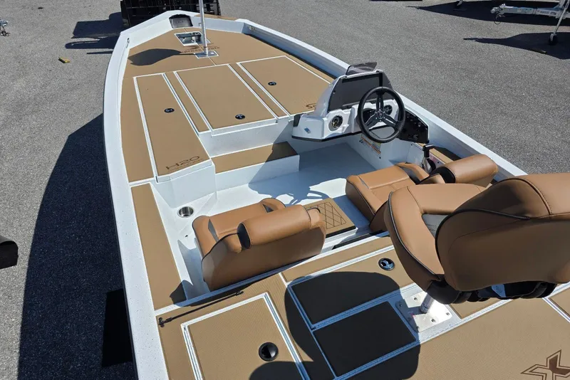 Slide: The Image of 2026 Xpress H20 Bass boat interior with tan seats and steering console. - 10
