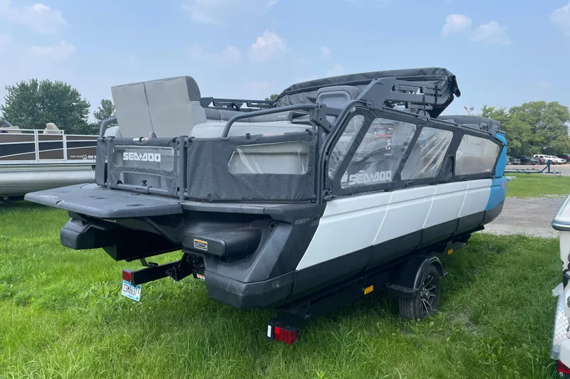 Slide: The Image of 2023 Sea-Doo Switch 21-230 pontoon boat on trailer, parked on grass. - 3