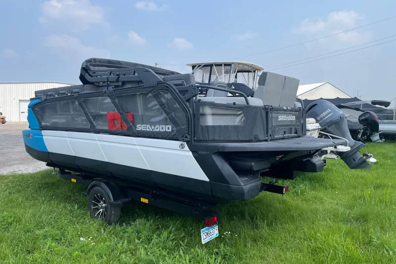 Slide: The Image of 2023 Sea-Doo Switch 21-230 pontoon boat on trailer, parked on grass. - 4