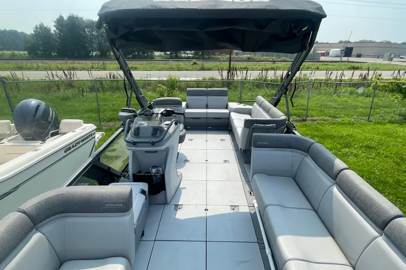 Slide: The Image of 2023 Sea-Doo Switch 21-230 pontoon boat with spacious seating and canopy, docked outdoors. - 5