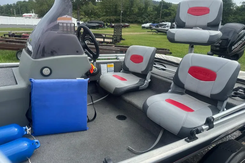 Slide: The Image of 2015 Tracker Pro 160 boat interior with gray and red seating, steering console, and accessories. - 5