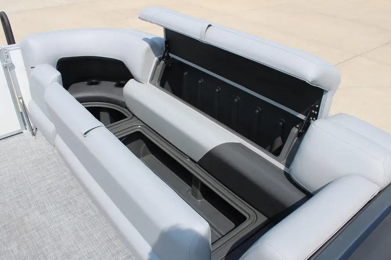 Slide: The Image of 2026 Sun Tracker Party Barge 20 DLX with open storage compartment and cushioned seating. - 12