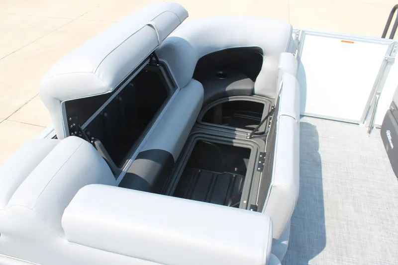 Slide: The Image of 2026 Sun Tracker Party Barge 20 DLX interior seating with storage compartments open. - 13