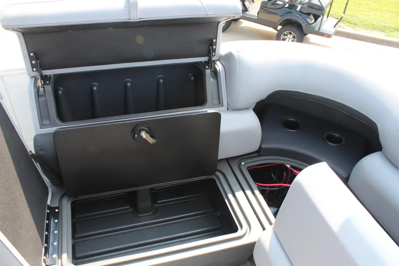 Slide: The Image of 2026 Sun Tracker Party Barge 20 DLX storage compartment with open lid and cup holders. - 15
