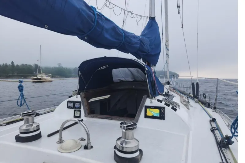 Slide: The Image of Sailing yacht "Peacock 35" from 1984 on a misty lake with forested shoreline. - 5