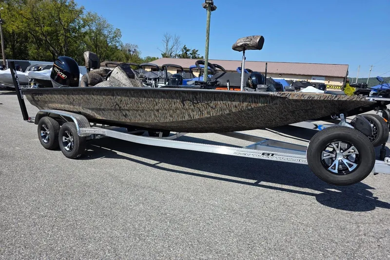 Slide: The Image of 2026 Xpress H20 Bass boat on trailer, featuring camouflage design and modern outboard motor. - 10