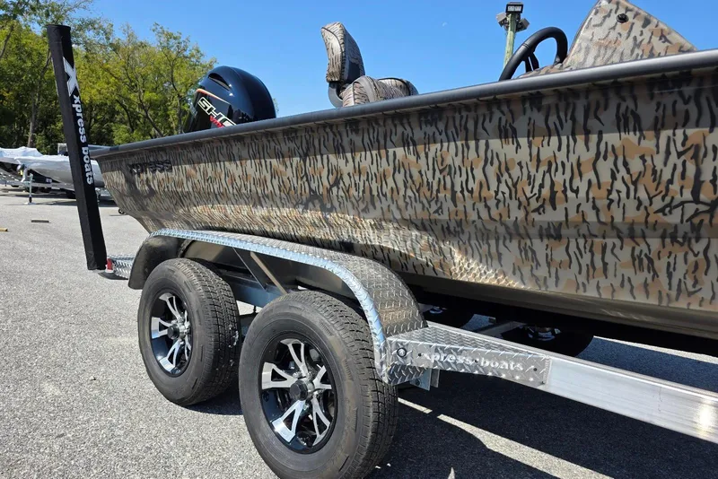 Slide: The Image of 2026 Xpress H20 Bass boat on trailer with camouflage design and dual wheels. - 11