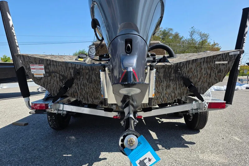 Slide: The Image of 2026 Xpress H20 Bass boat rear view with camouflage design and trailer. - 14