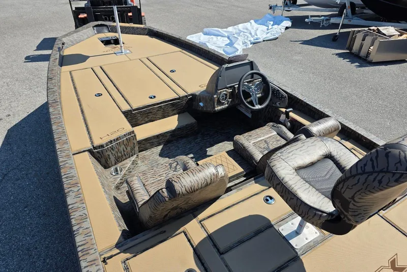 Slide: The Image of 2026 Xpress H20 Bass boat interior with camouflage seats and steering console. - 15