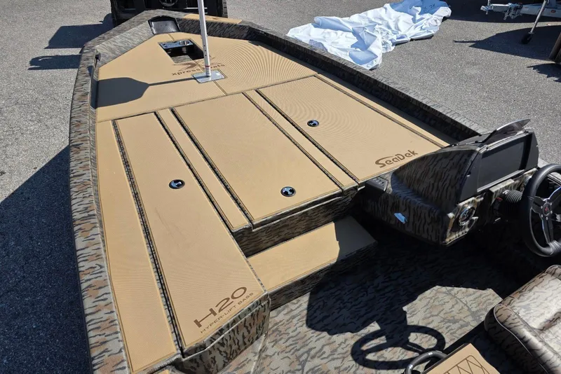 Slide: The Image of 2026 Xpress H20 Bass boat with camo design and SeaDek flooring. - 16