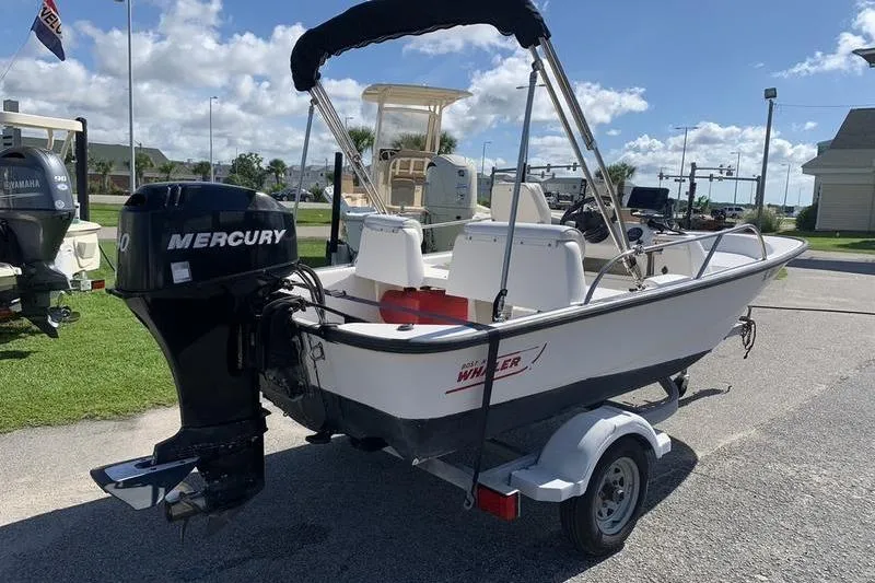 Slide: The Image of 2007 Boston Whaler 130 Sport boat with Mercury engine on trailer, parked outdoors. - 4