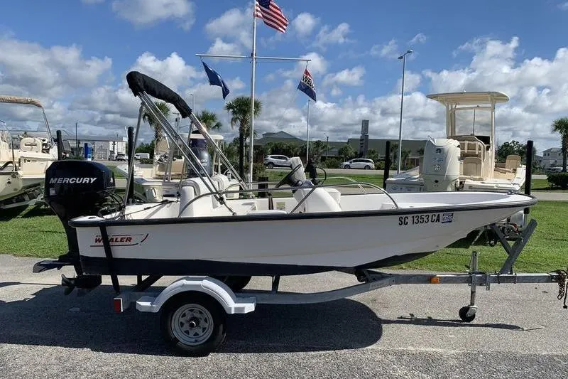 Slide: The Image of 2007 Boston Whaler 130 Sport boat on trailer, parked outdoors under a clear sky. - 5