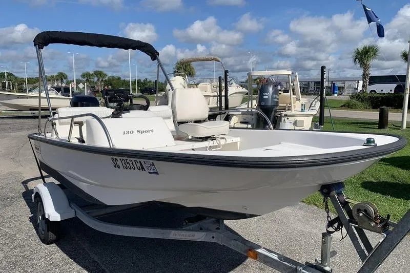 Slide: The Image of 2007 Boston Whaler 130 Sport boat on trailer, parked outdoors under a blue sky. - 6