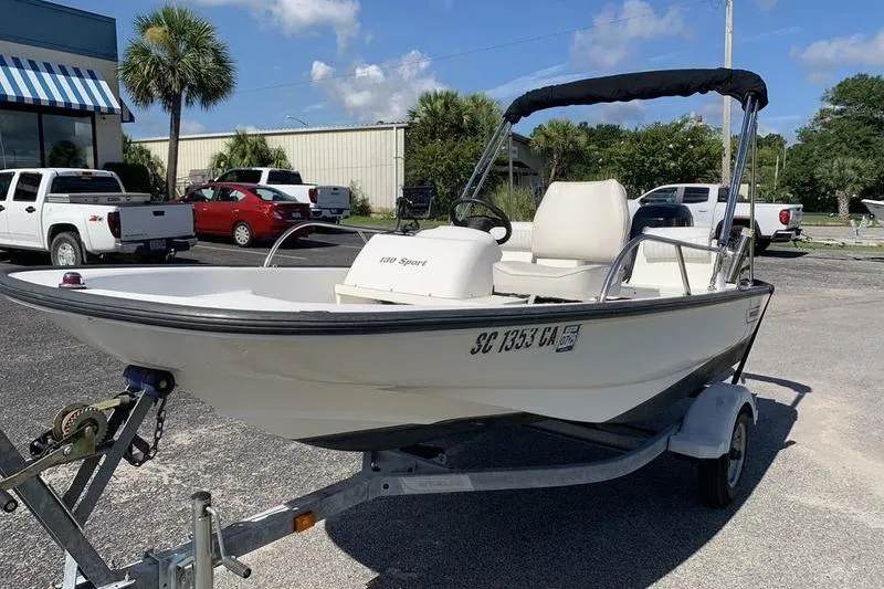 Slide: The Image of 2007 Boston Whaler 130 Sport boat on trailer, parked outdoors under clear sky. - 8